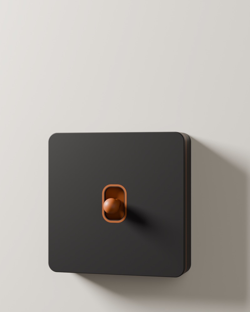Graphite cover with a copper ring and sphere knob on a pale wall